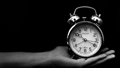 Timed coding challenge for interview A small clock being held by an outreached arm - this represents the timed challenges often used within coding interviews.